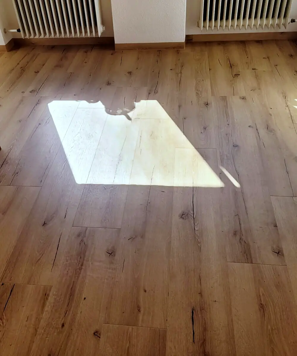 Frisch verlegter Boden in Holzoptik, auf den Sonnenlicht fällt